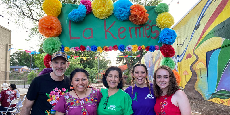 people smiling in front of a nonprofit event sign