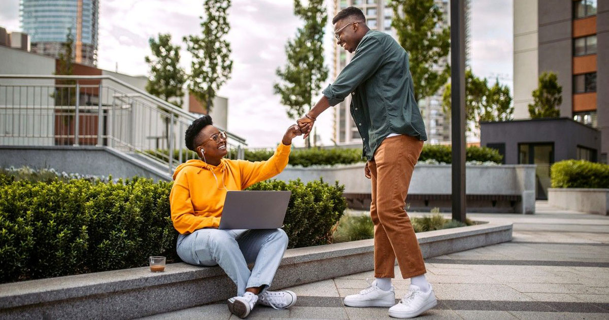 Friends greeting eachother with a fist bump outside