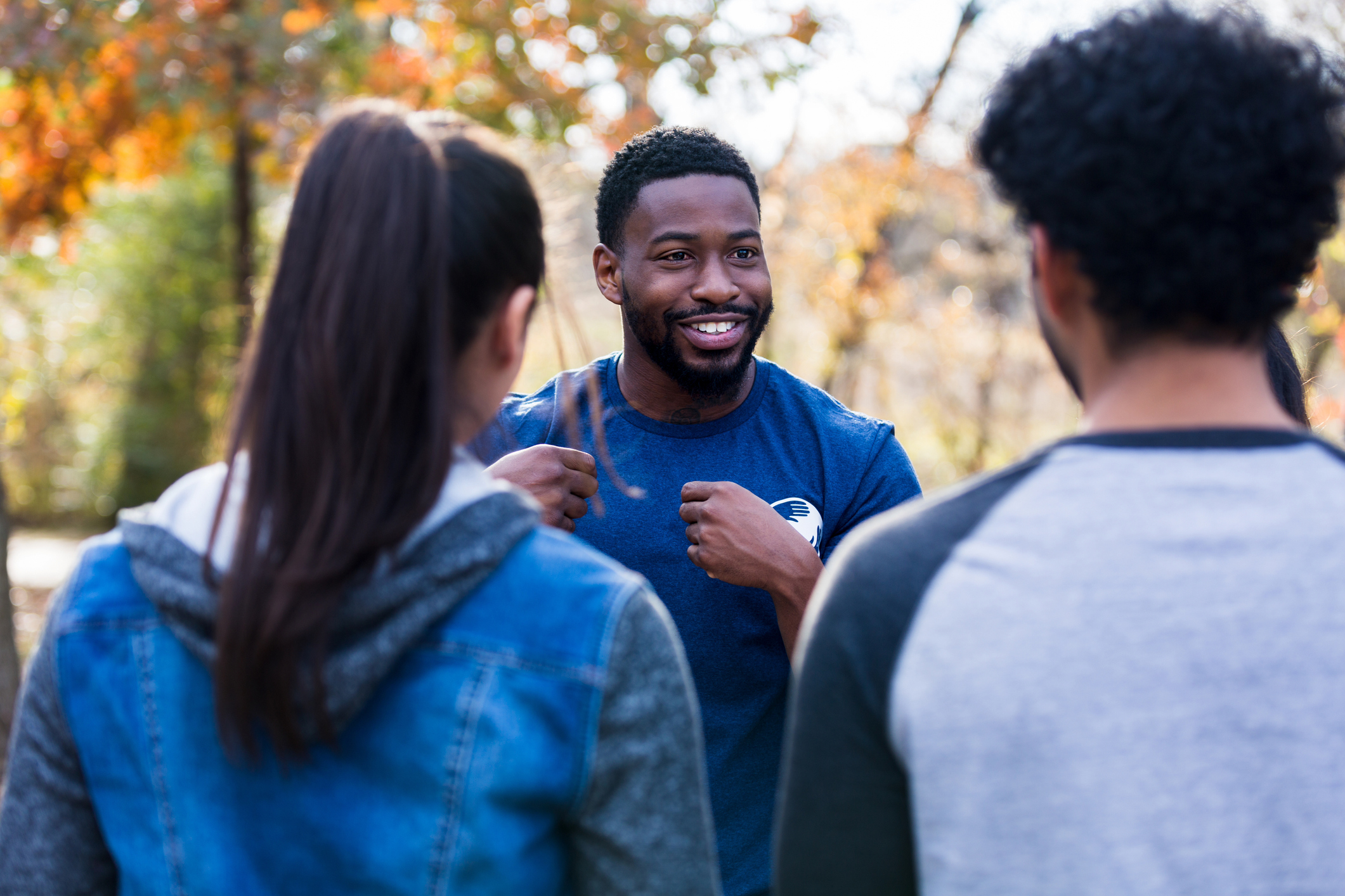 Male volunteer talking with two other individuals.